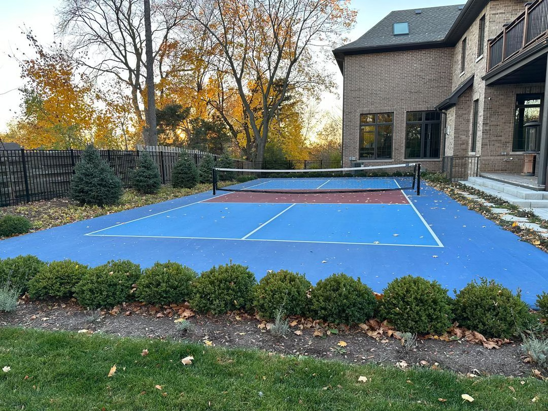 A pickleball paddle and ball on a pickleball court